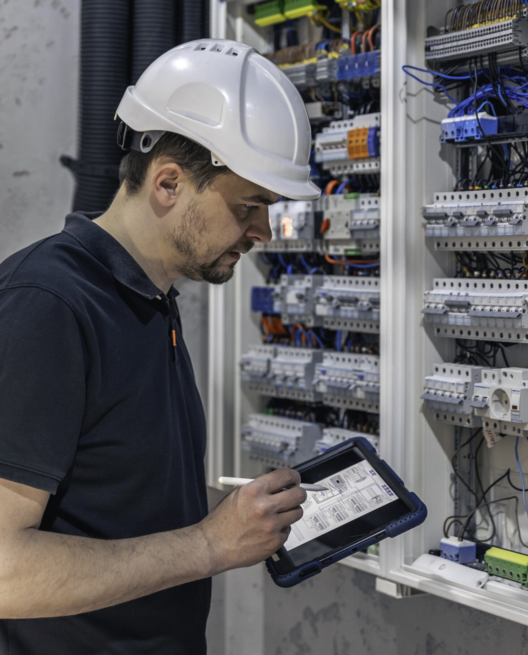 Man, an electrical technician working in a switchboard with fuses.